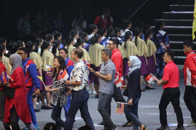 Mr Johari Bin Wahiad having a whale of a time at the parents' and coaches march past during the Opening Ceremony of the 9th ASEAN Schools Games.