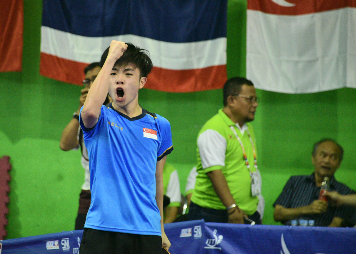 Lim Dao Yi punching his fist in the air after scoring the final point against Malaysia’s Christopher Isaac in the boys’ team final.
