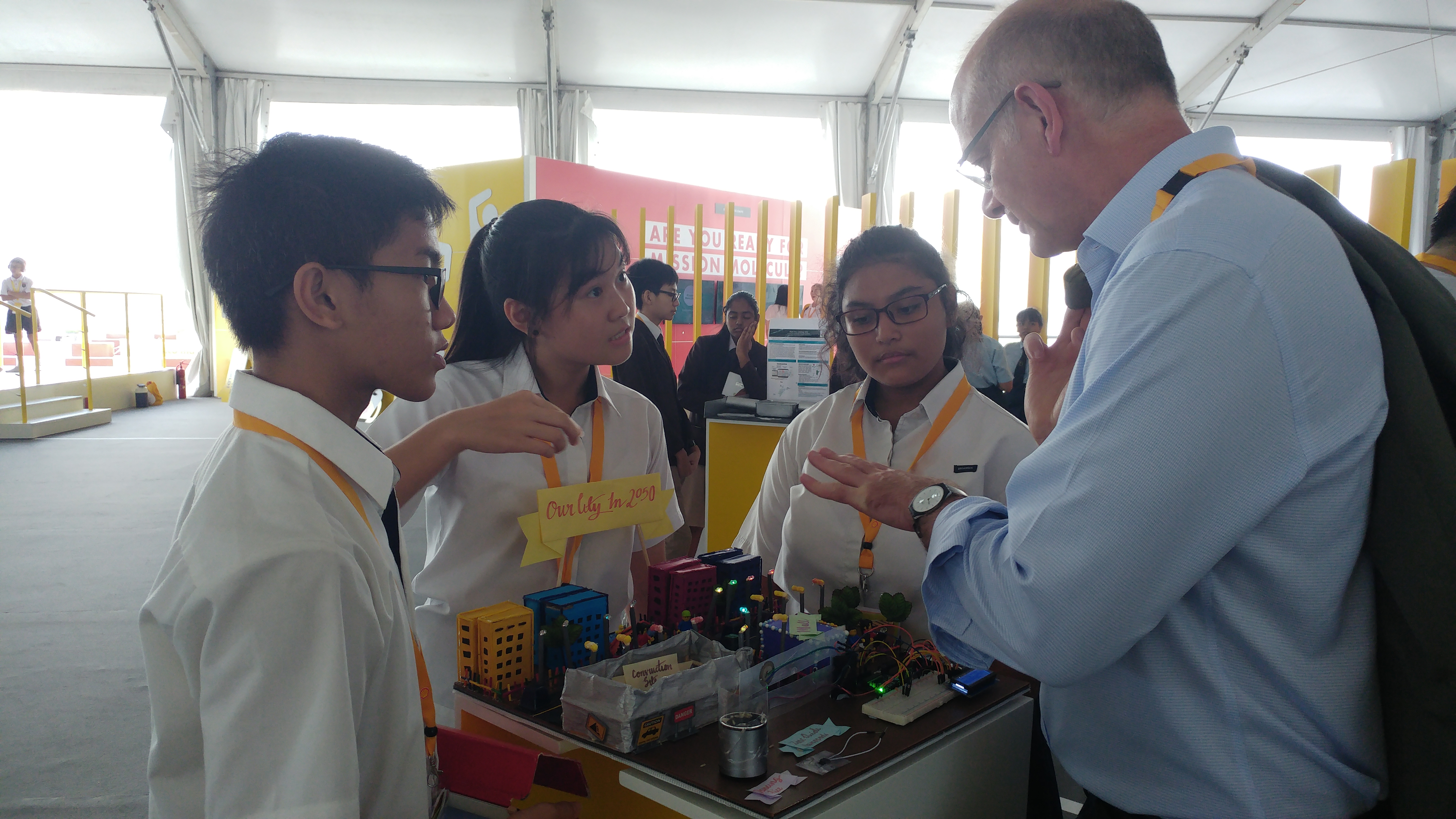 Benjamin, Siyu and Aminah of “The Triggered Team” explaining their prototype to the members of the public.

Photo credit: Broadrick Secondary School
