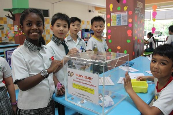 Faith (left) and her Primary 3 schoolmates manning the donation box.