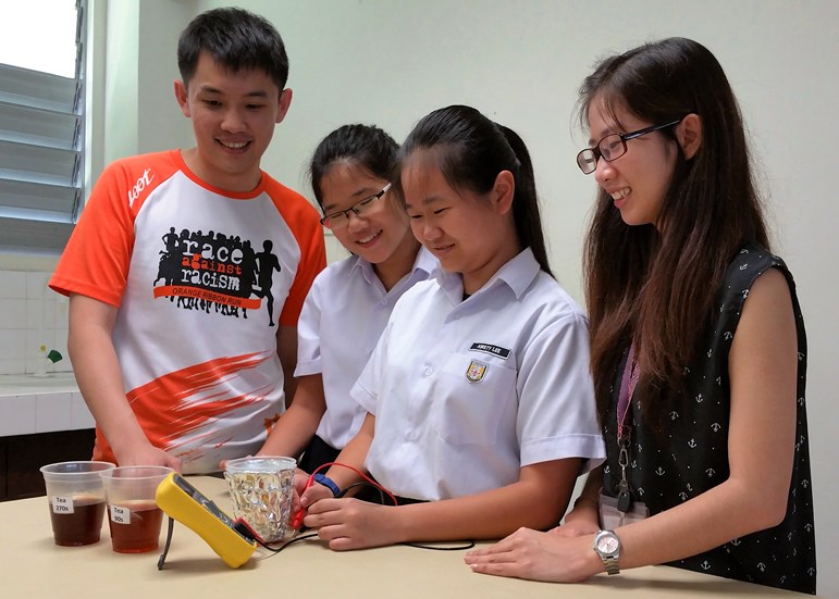 Student Kristy Lee (second from right) finds out the strength of tea by measuring the amount of light it absorbs. Stronger tea tends to be darker and absorbs more light. (Photo credit: Dunearn Secondary School)