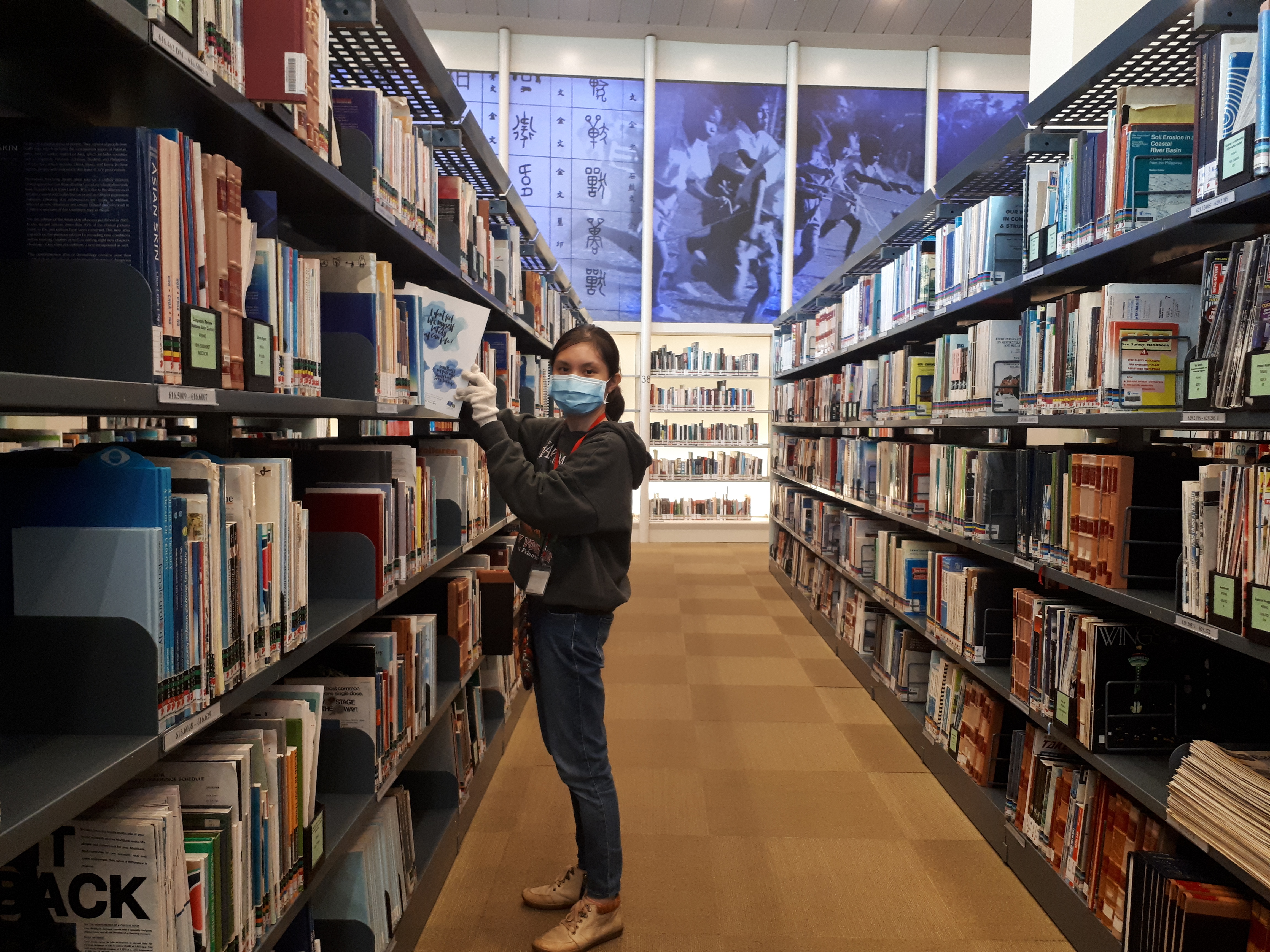 Hui Qing shelving books at the National Library.