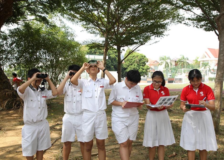 Students of Chung Cheng High School (Main) observing birds in trees at their school campus.
