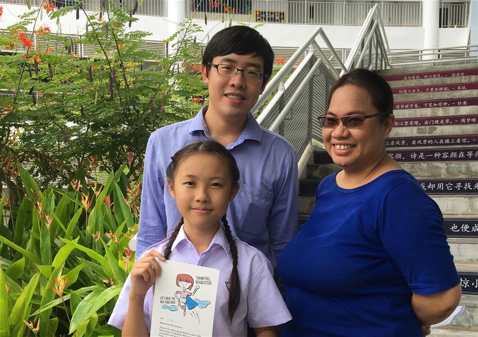 Wenyao with her Form teachers, Mr Raymond Teo and Ms Jennifer Lai. In her hands, a Thank You card from her teachers for doing her part to contain the spread of the virus.