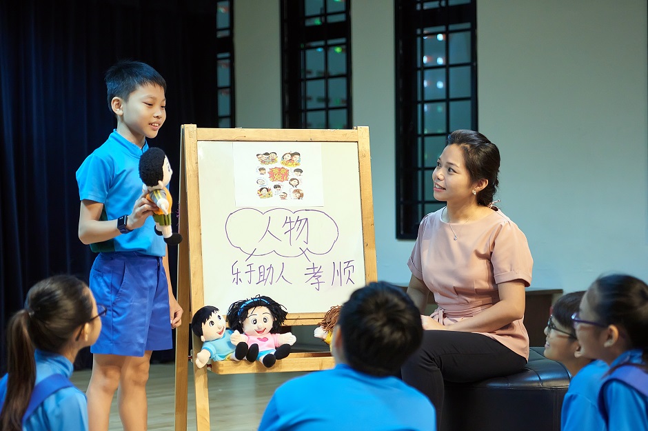 Madam Ng helping her students learn new vocabulary and values through role play