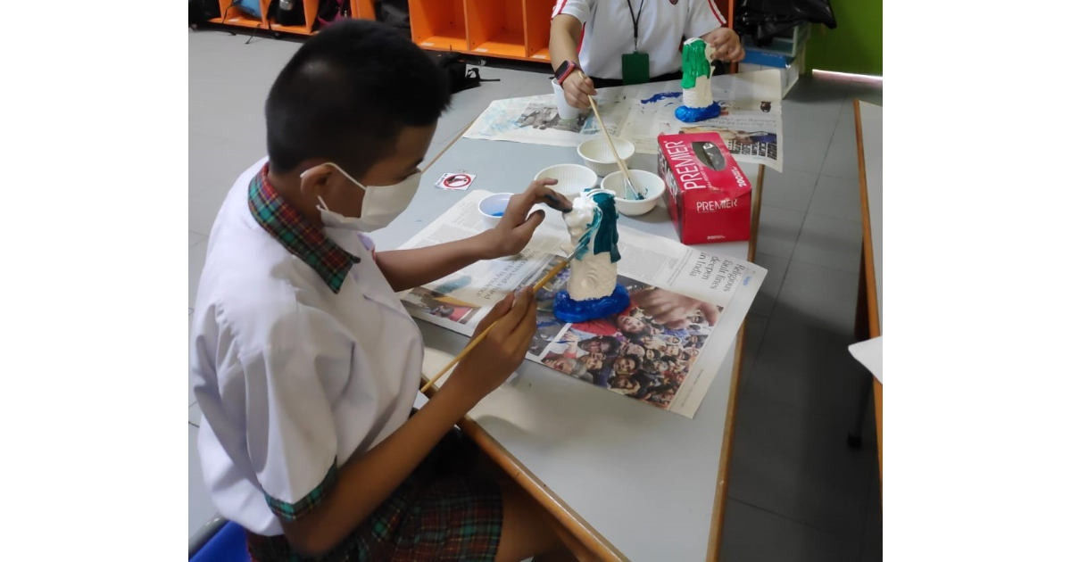 Students work on painting miniature Merlion sculptures