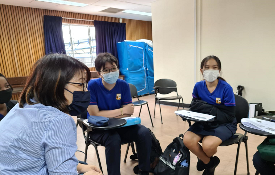 Serangoon Secondary School Peer Support Leaders Kris Toh and Kate Lau attending a training session on helping victims of hurtful behaviour. Facilitating their discussion is Mdm Jade Chee, their Senior School Counsellor.	