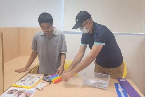 Mr Viren demonstrating how to identify and sort out different denomination notes during a numeracy lesson.