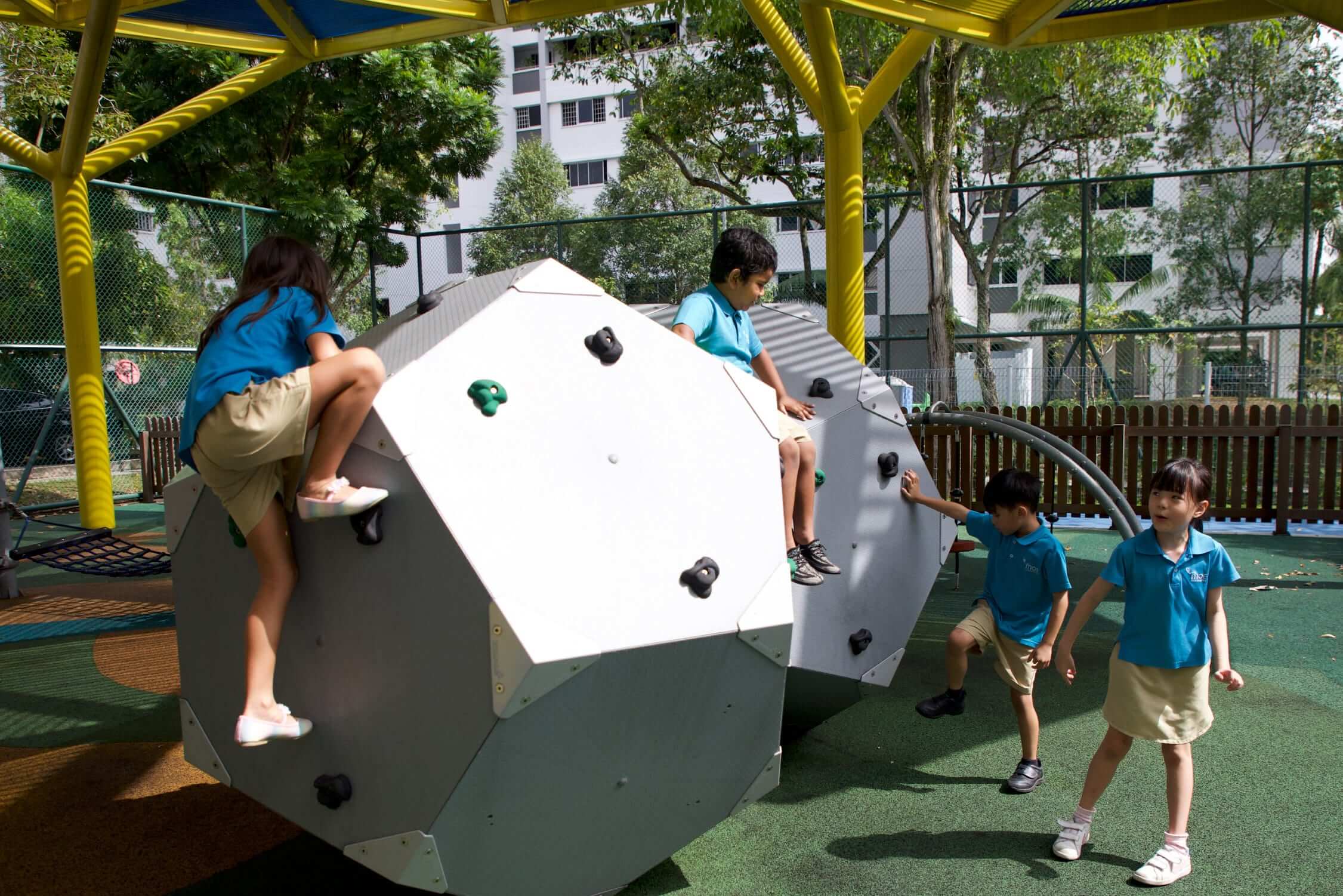 kindergarteners climbing at a playground